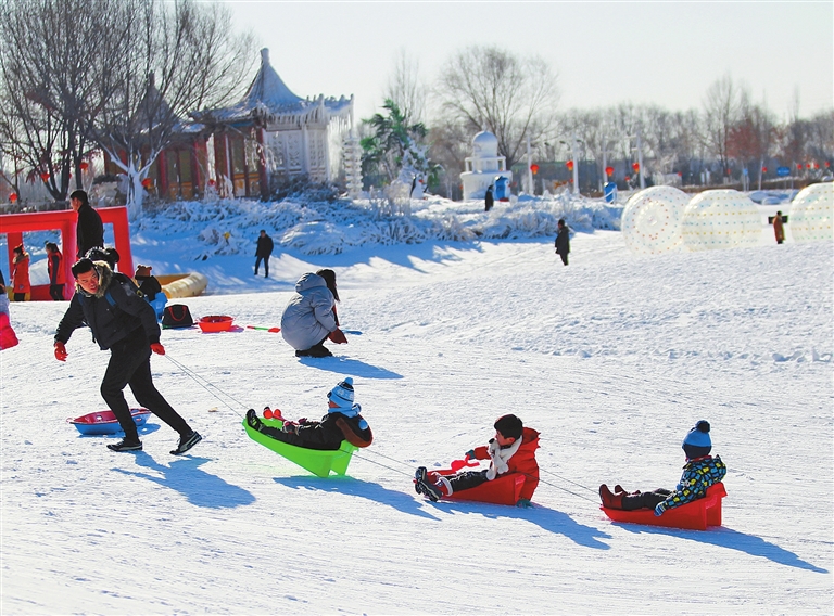 游客在呼和浩特市南湖湿地公园冰雪世界享受冰雪乐趣.