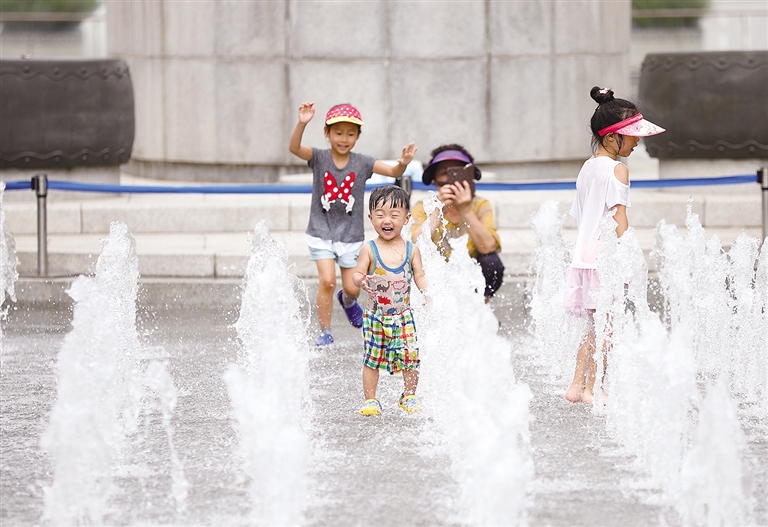 8月3日,在韩国首尔光化门广场,孩子们在喷泉中玩耍