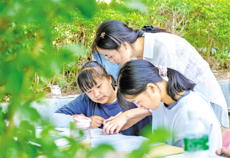 5月24日,漾濞一中老師(中)在輔導高三年級學生.